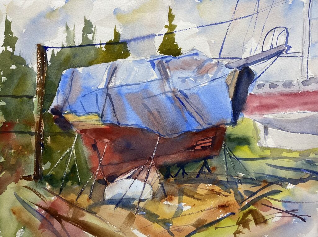An old wooden boat in a boatyard covered with a blue tarp